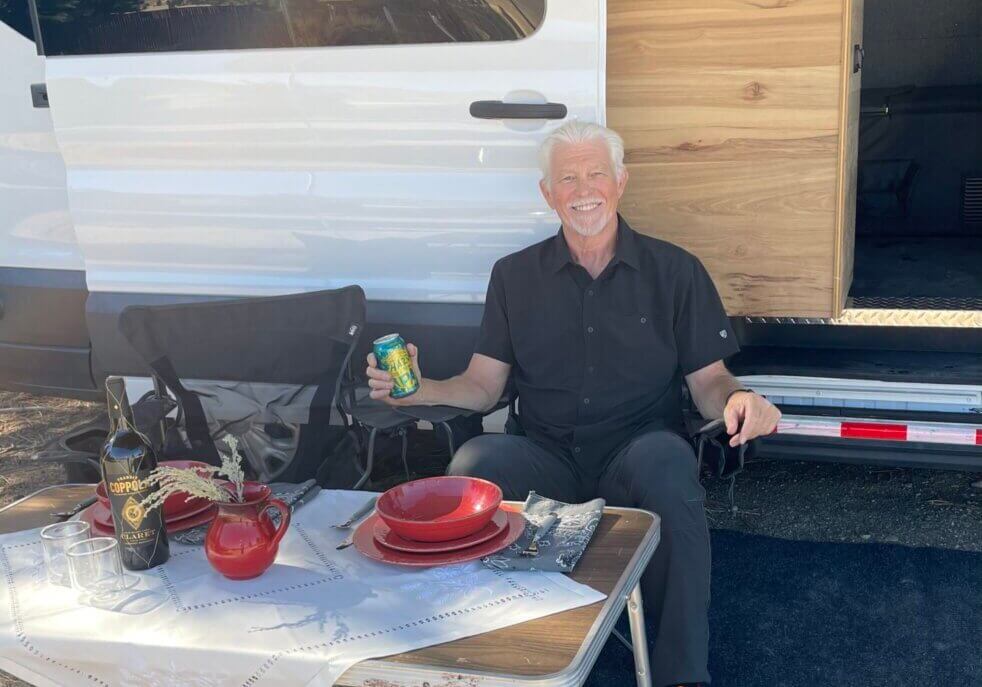 Dean sitting outside of conversion van